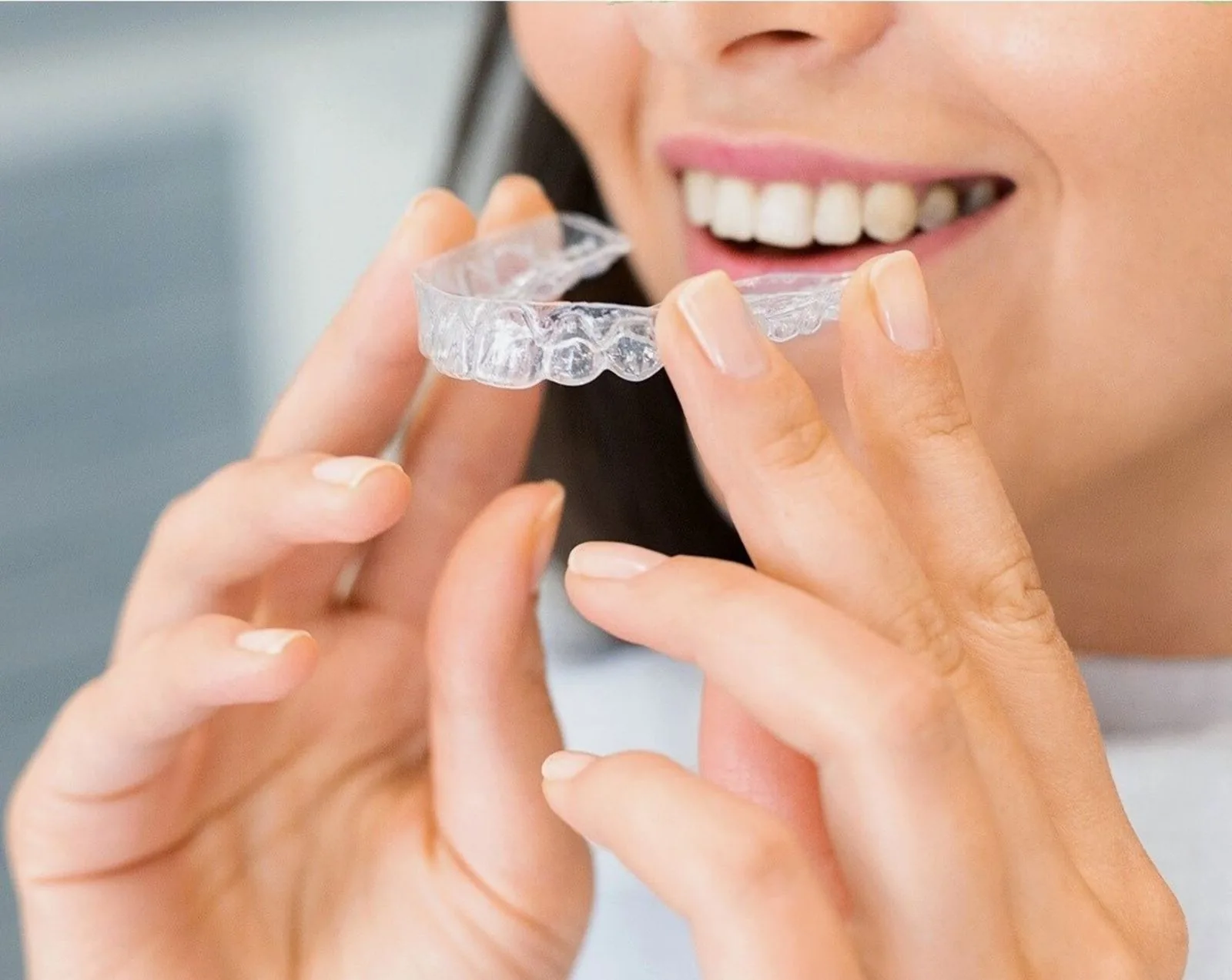 Aligner transparent ținut între degete